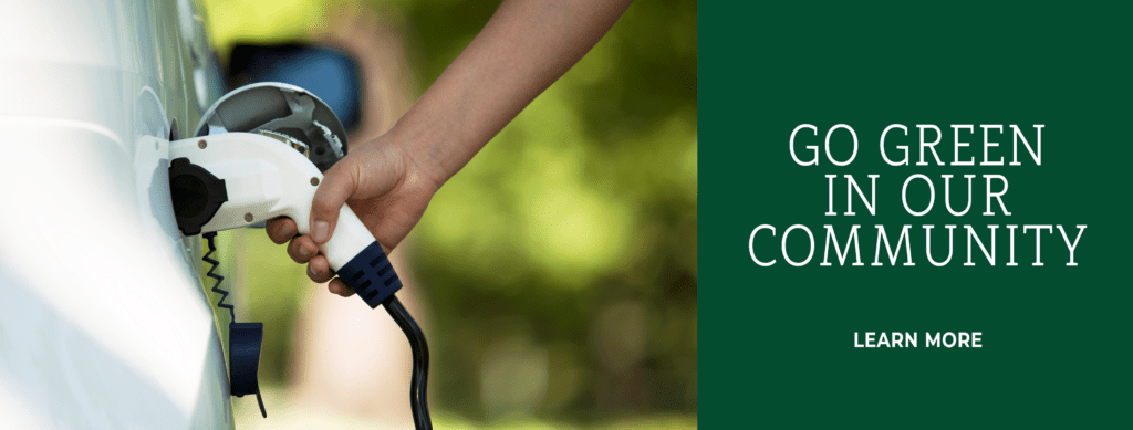 Go green in our community. Learn more. Image: Someone plugging in an electric vehicle.