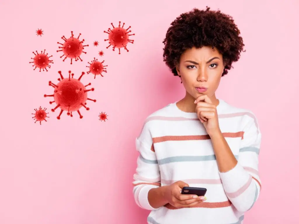 COVID-19 scam image of person thinking while holding a phone.