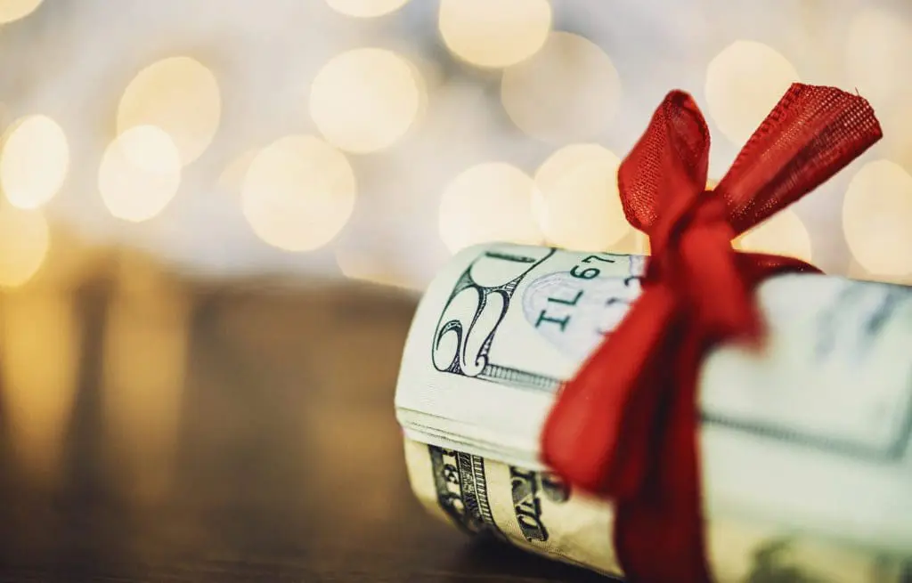 Christmas cash. Wad of American currency tied with red ribbon