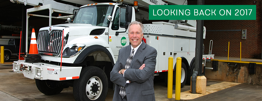 CEO Steve Hamlin in front of a Piedmont Electric bucket truck. Text: Looking back on 2017