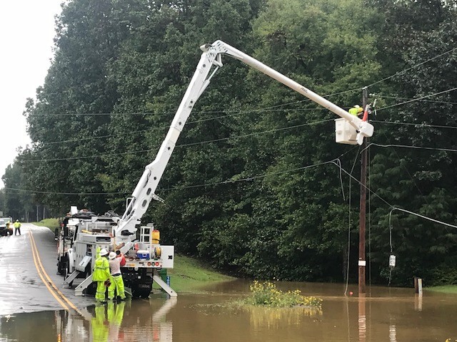 Crews fixing wire over flooded ground
