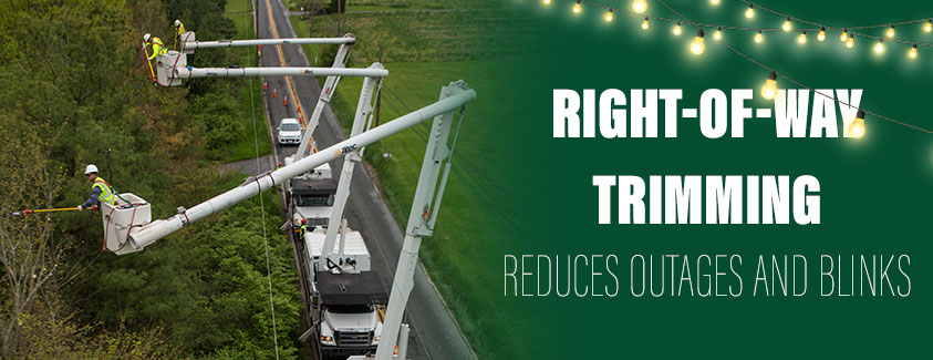 Right-of-way trimming reduces outages. Image of bucket trucks clearing trees