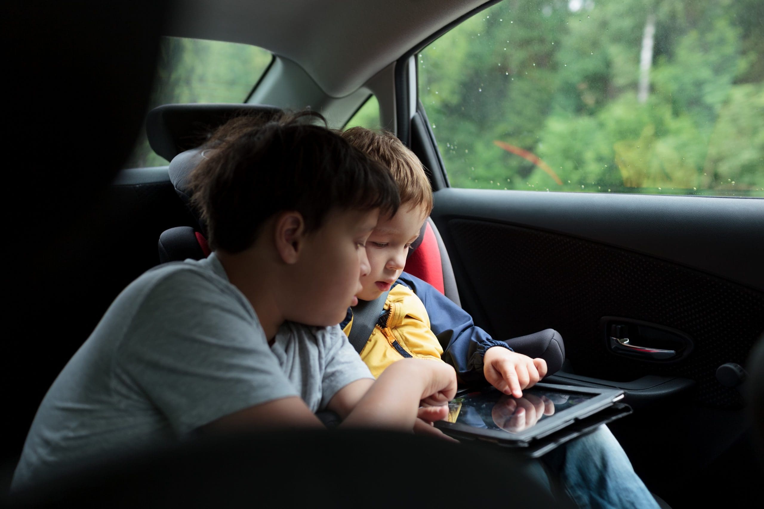 Boys in the car using a touchpad