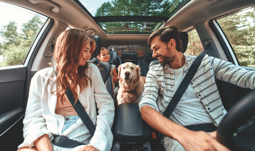 Family and dog sit happily in an electric vehicle